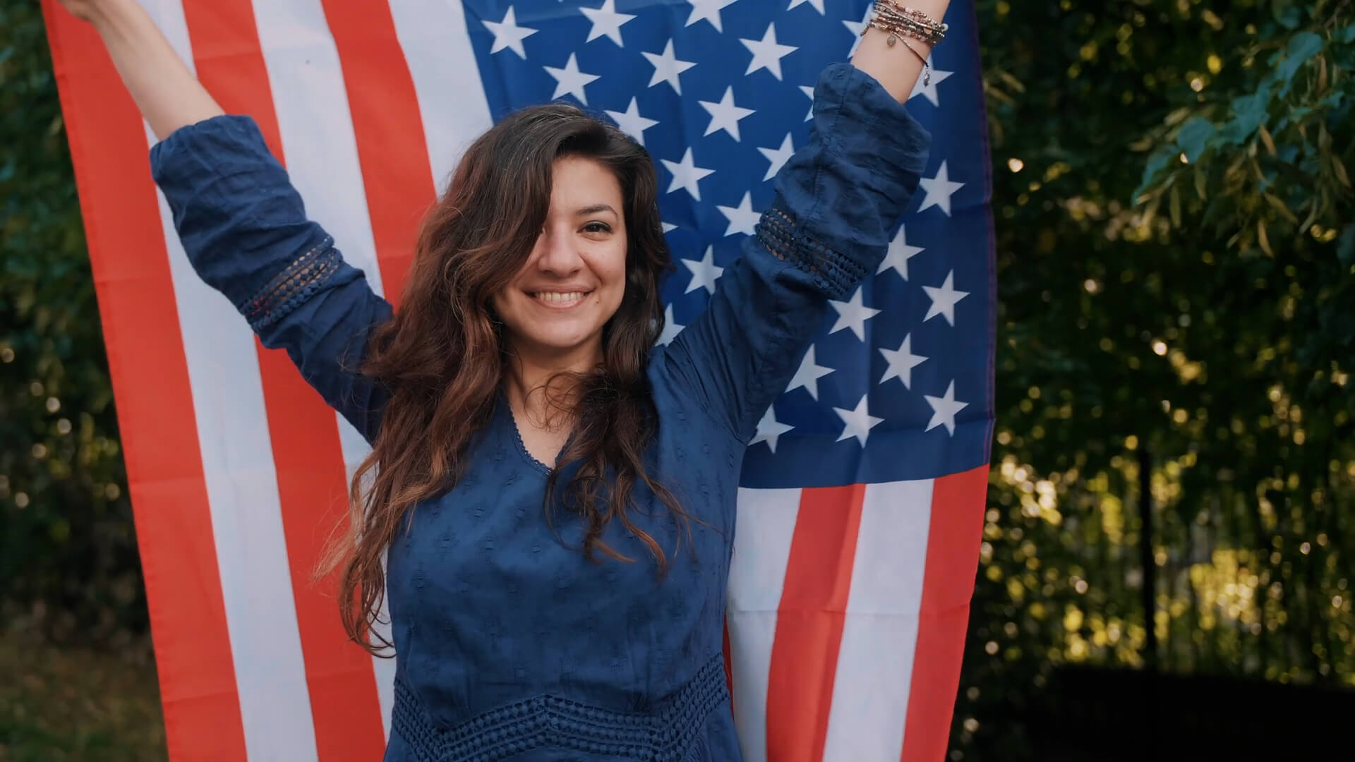 A woman holding the American flag, representing the widespread use of English in the United States