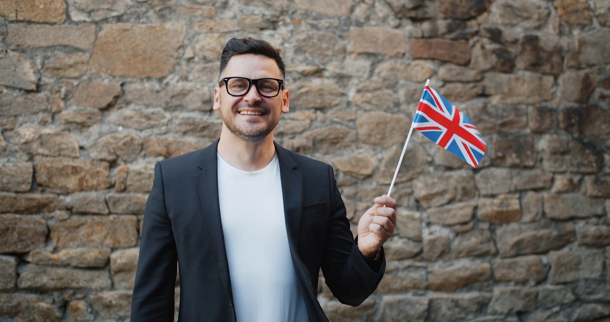 A man proudly holding the British flag, symbolizing English as the primary language in the UK